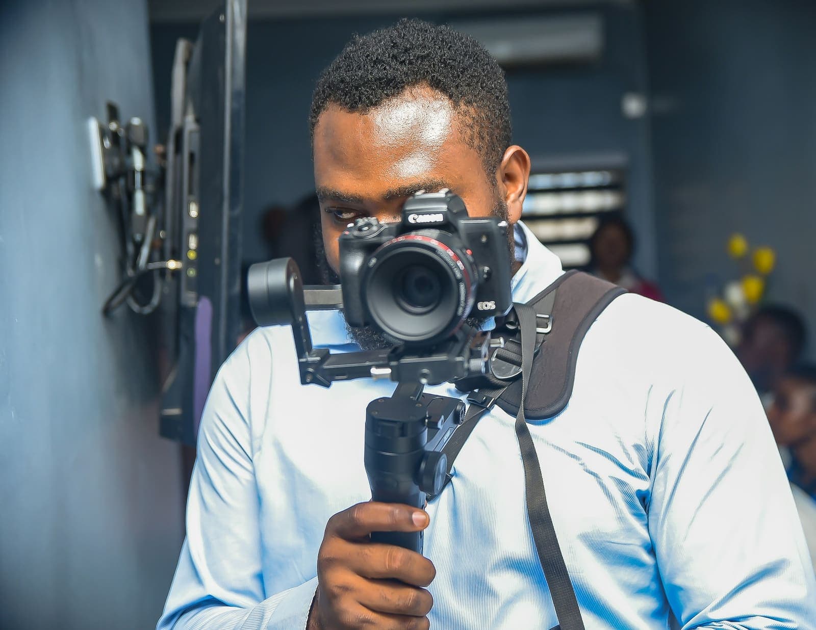 Un vidéaste filme avec une caméra sur stabilisateur.