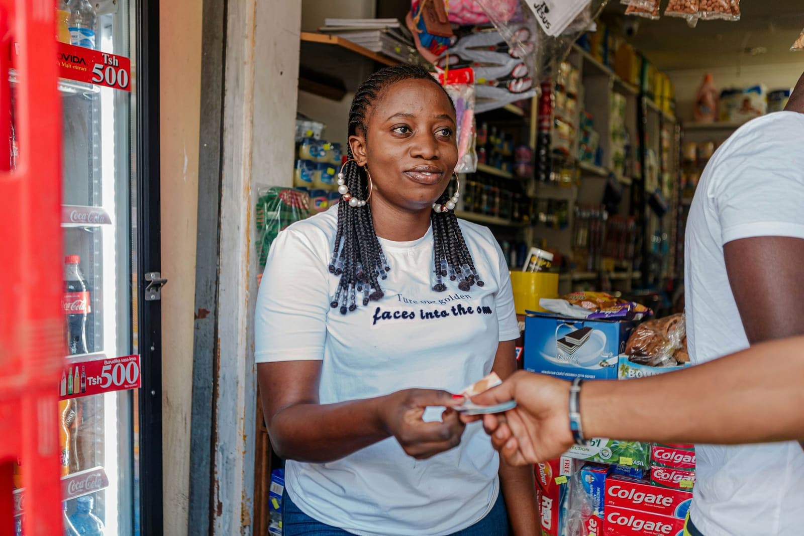 Une commerçante reçoit un paiement au comptoir.