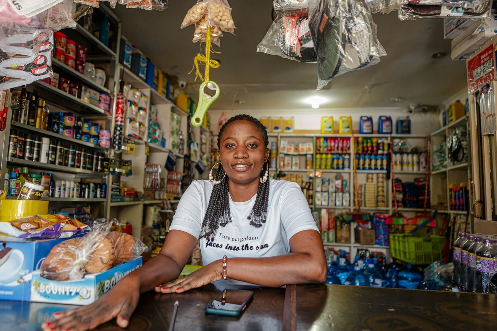 Une commerçante derrière le comptoir de son épicerie.